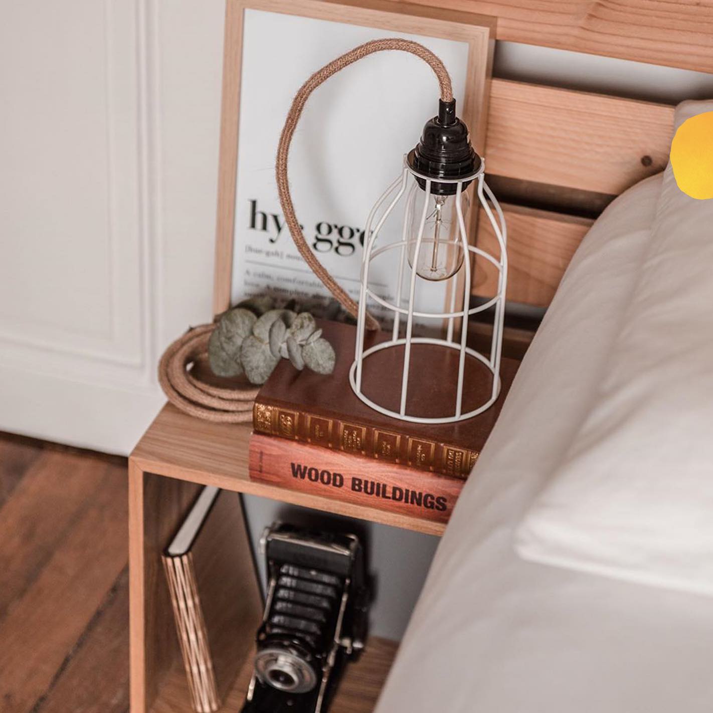 lampe baladeuse posé sur une table de chevet en bois