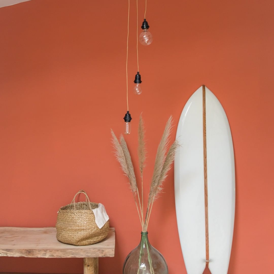 Suspension luminaire Hoopzi dans une pièce colorée avec mur orange et surf blanc